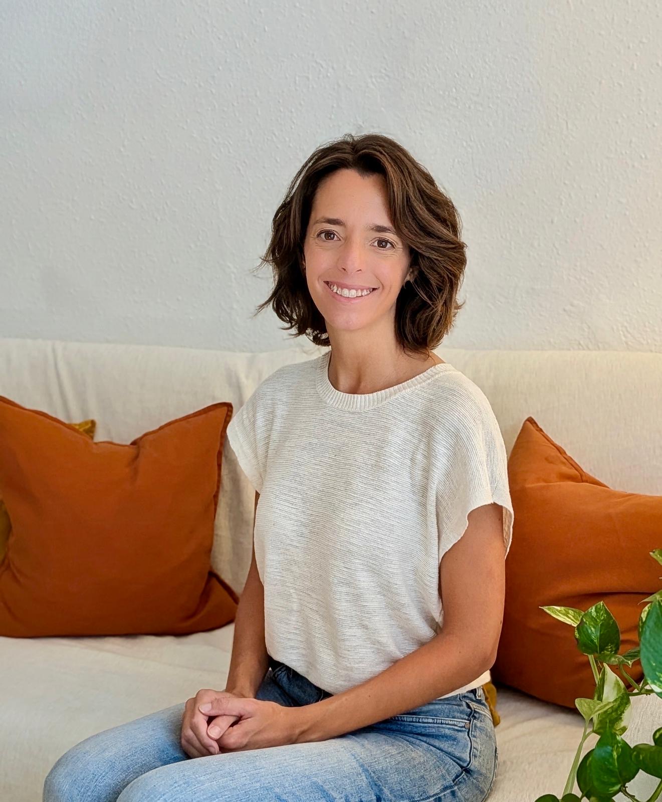 Cristina Magriñá smiling, seated on a couch